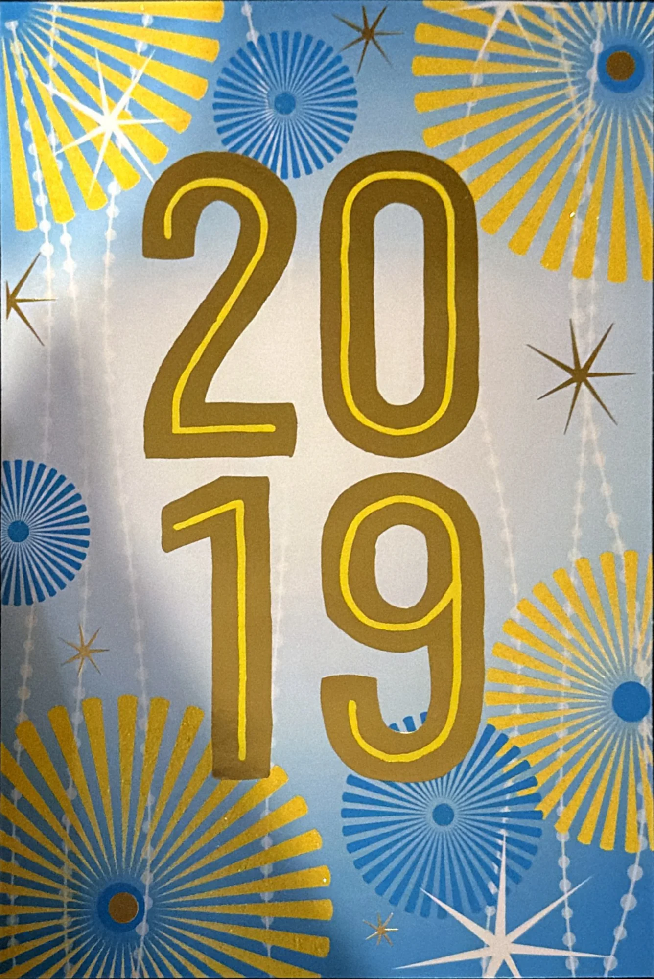 Large gold numerals 2019 over blue and gold starbursts.