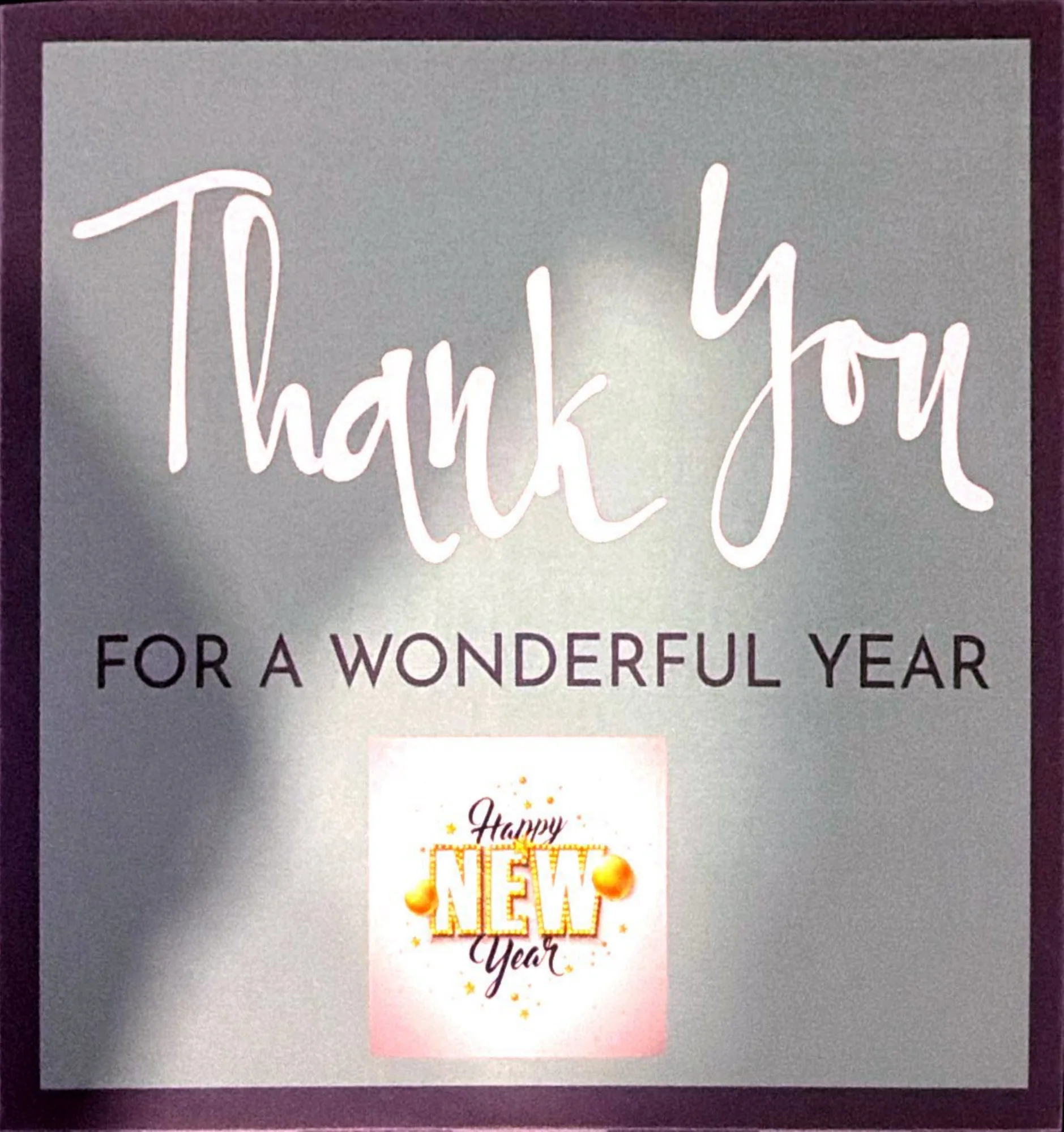 Grey card with white script Thank You, the line For a Wonderful Year, and a Happy New Year graphic.