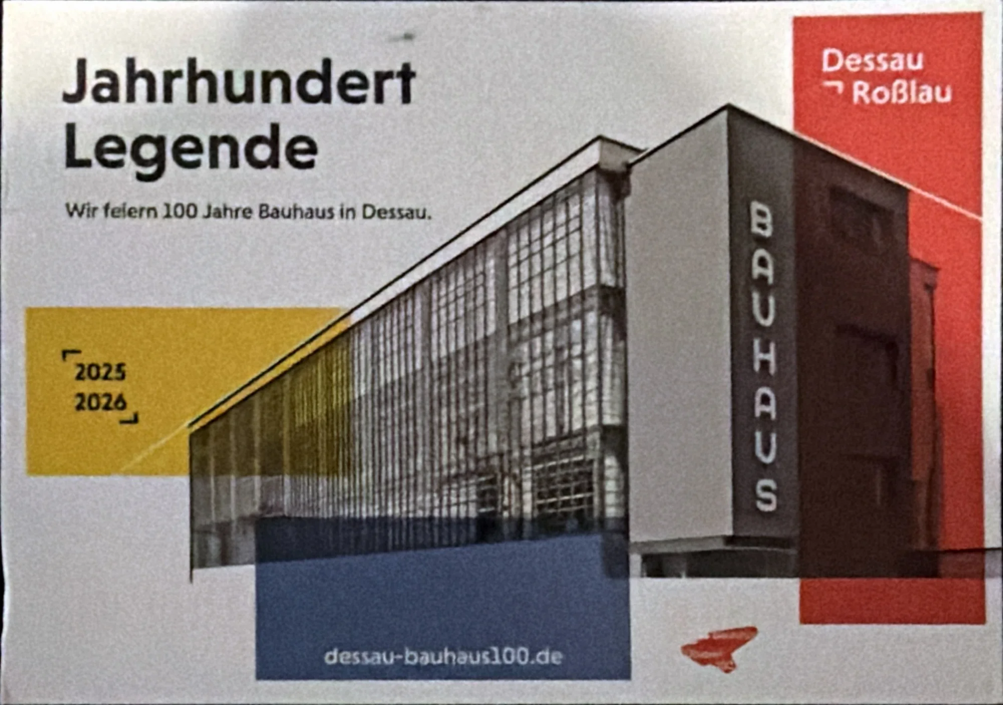 Graphic of the Bauhaus building in Dessau with yellow, blue and red blocks and the words Jahrhundert Legende.